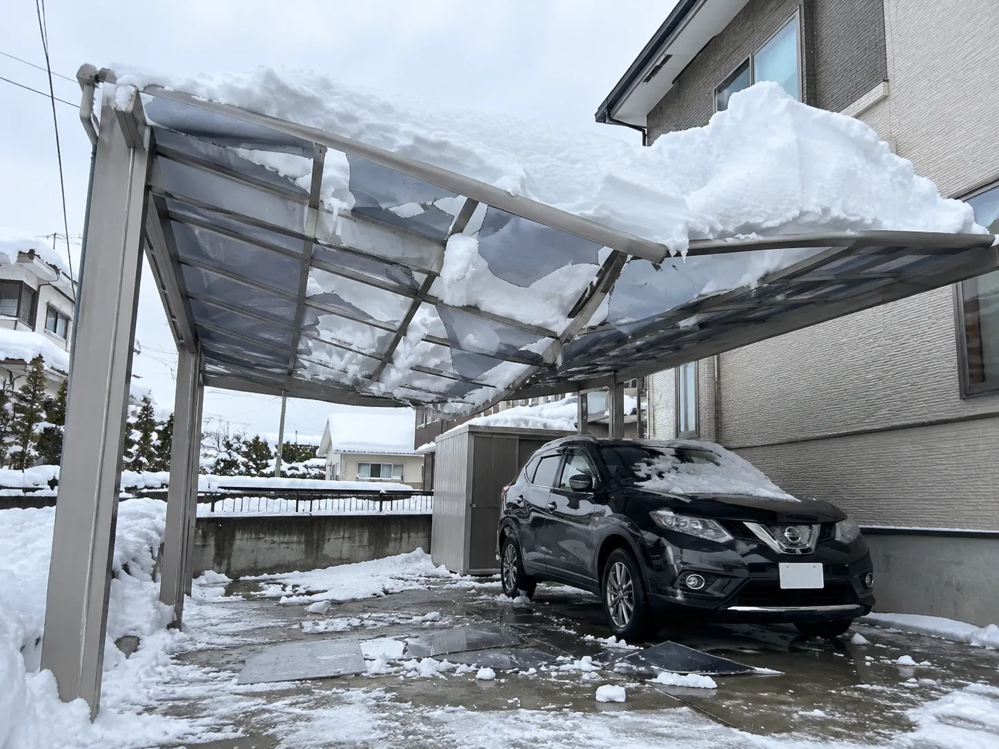 雪の重みで屋根が破損したカーポート